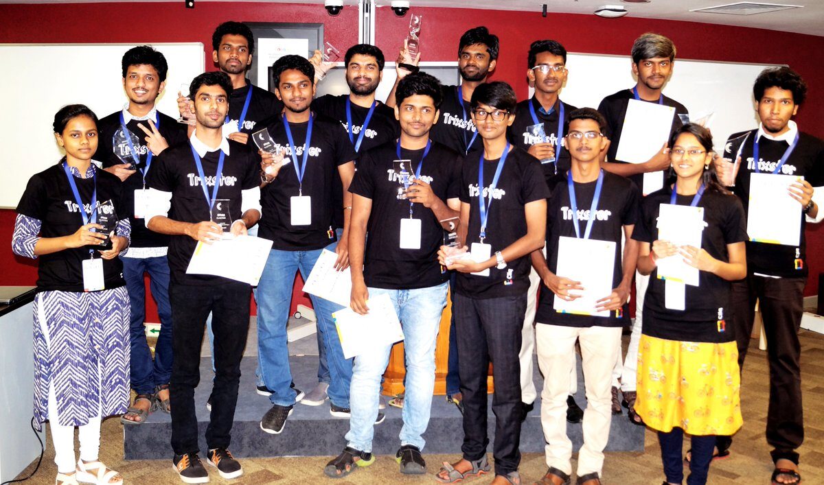 Cliqtrix winners in black Trixster t-shirts holding up their trophies and certificates